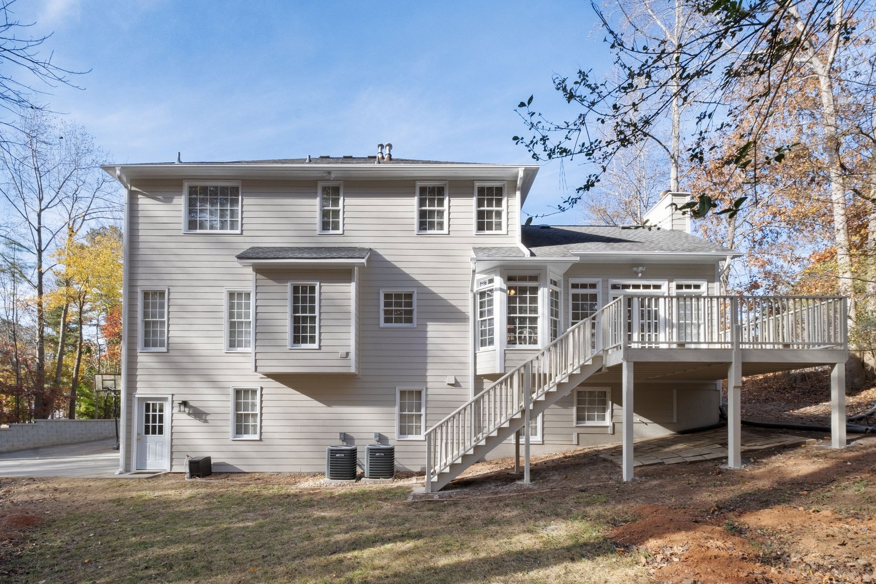 Back of the home with deck and stairs to the yard