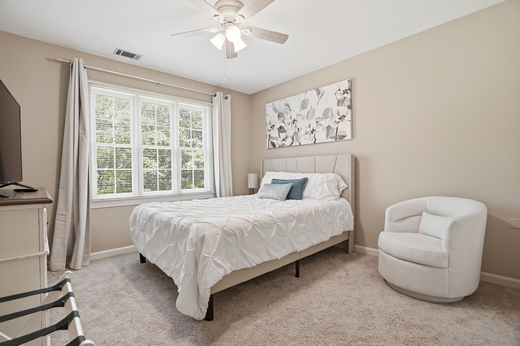 Bedroom with upholstered headboard and accent chair