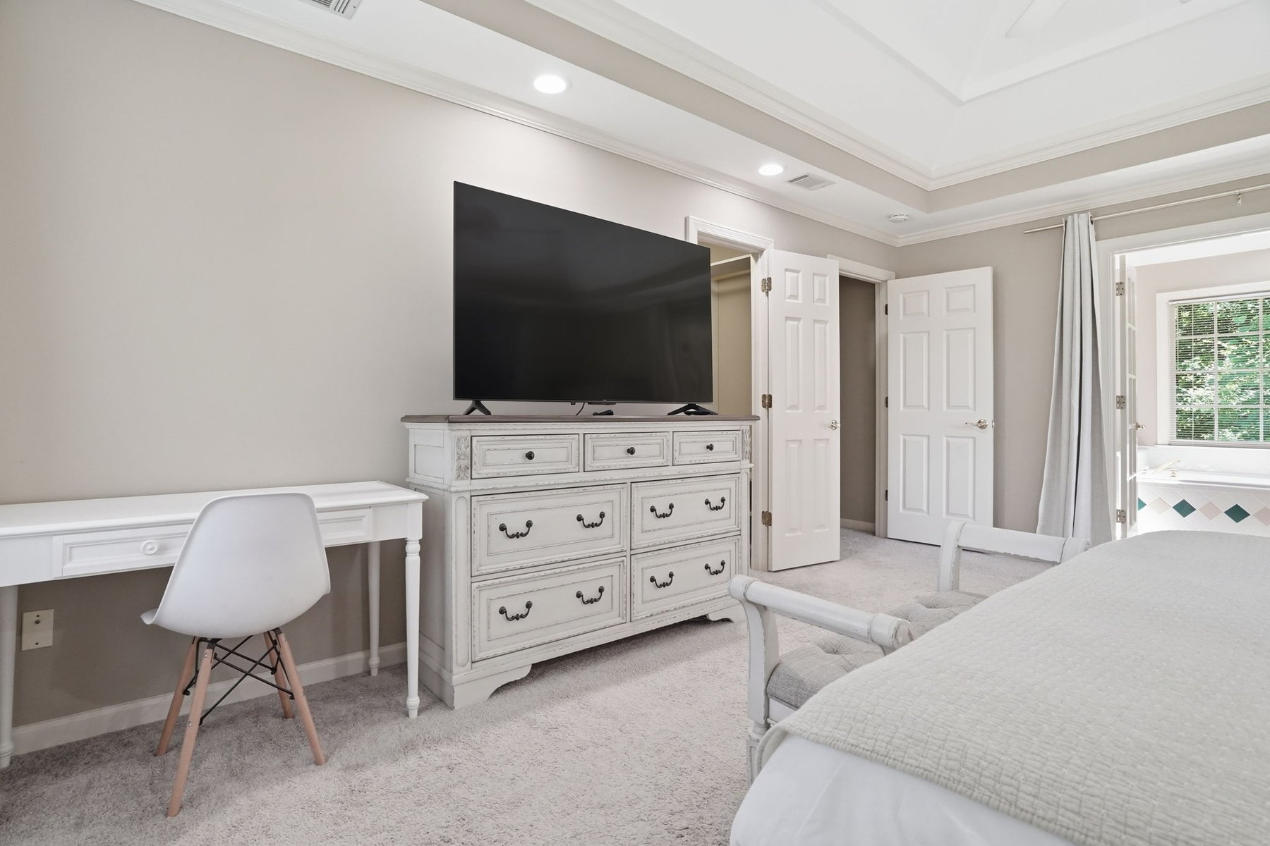 Bedroom with a bed, dresser, and windows