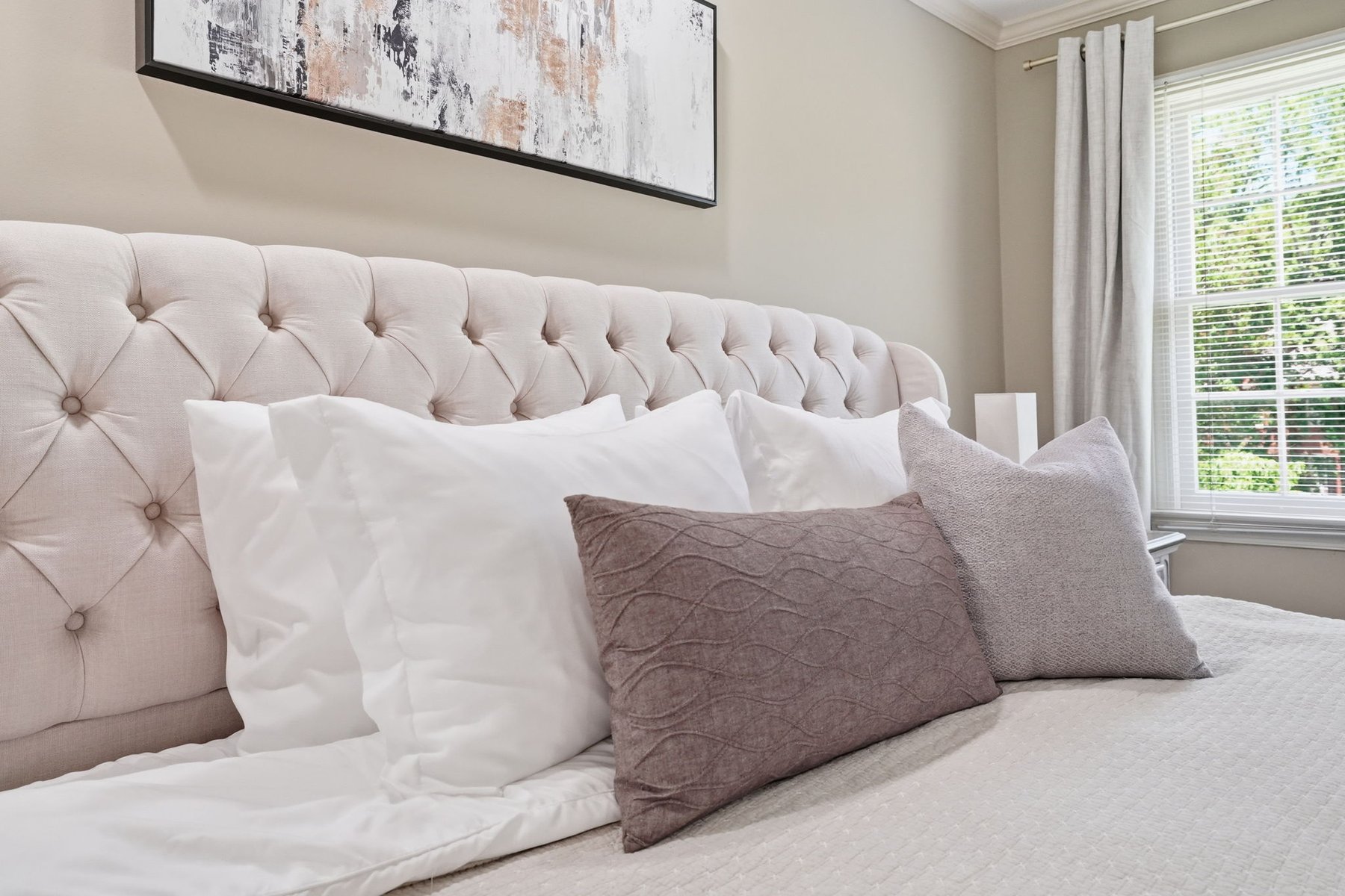 Bedroom with a wide window and neutral furnishings
